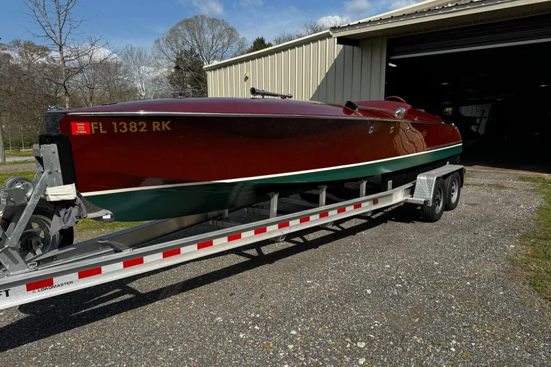 Slide: The Image of 2014 Hacker-Craft 26' Runabout on trailer outside a garage. - 2
