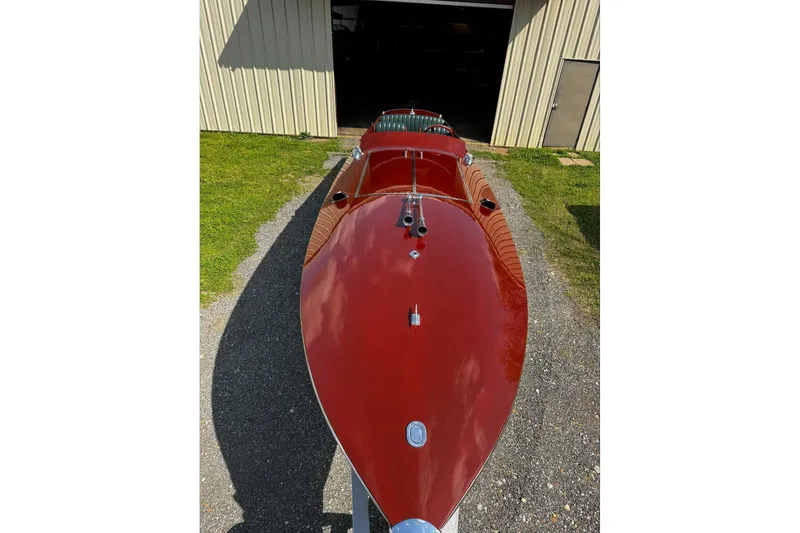 Slide: The Image of 2014 Hacker-Craft 26' Runabout with glossy red finish, parked outside a garage. - 5