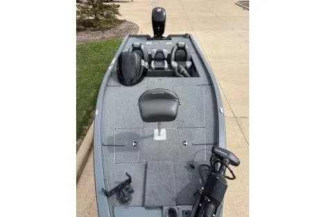 Slide: The Image of 2018 Lund 1875 Pro-V Bass boat with seating and motor, docked on pavement. - 4