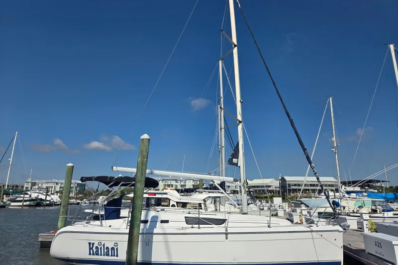 The Image of 2005 Hunter 31 sailboat docked at marina under clear blue sky. - 0