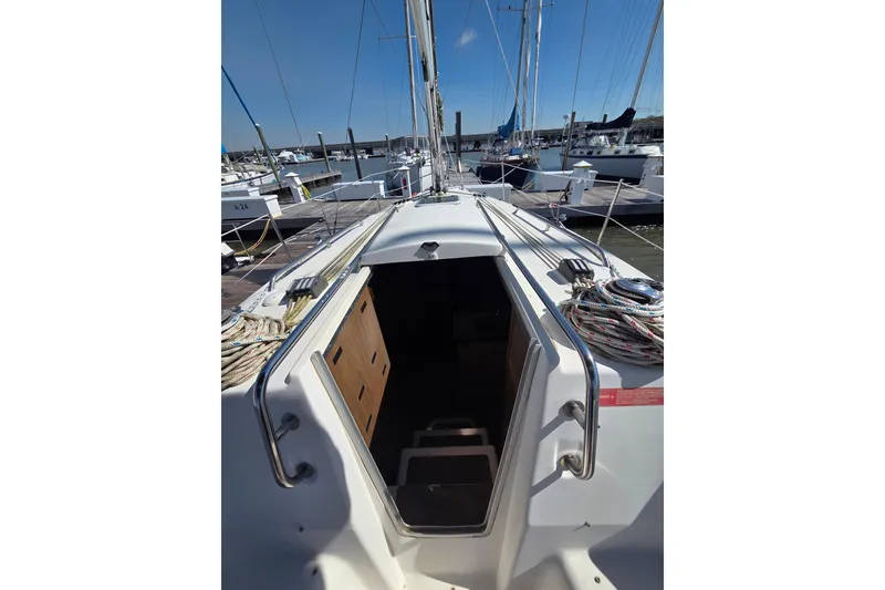 Slide: The Image of 2005 Hunter 31 sailboat cockpit view, docked in a marina under clear blue skies. - 15