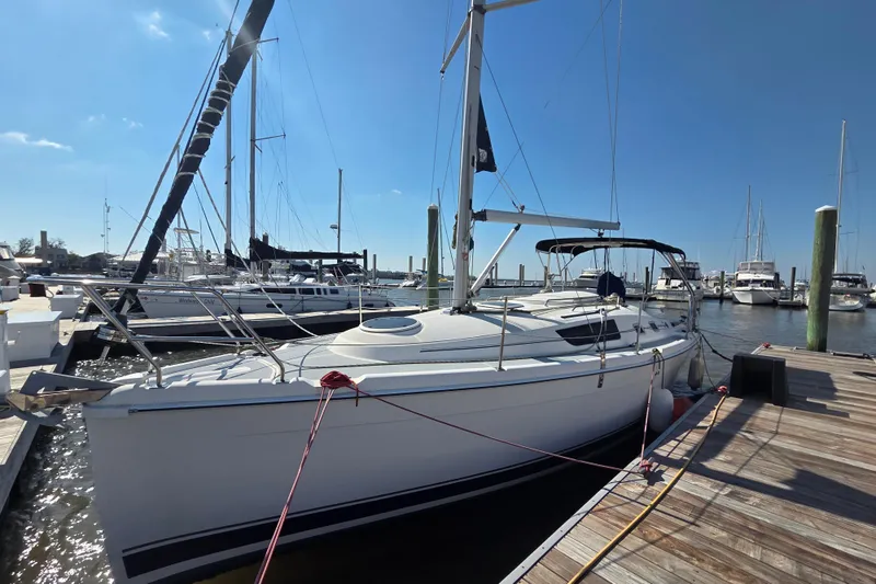 Slide: The Image of 2005 Hunter 31 sailboat docked at marina under clear blue sky. - 2