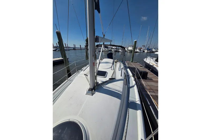Slide: The Image of 2005 Hunter 31 sailboat docked at a marina under clear blue skies. - 21