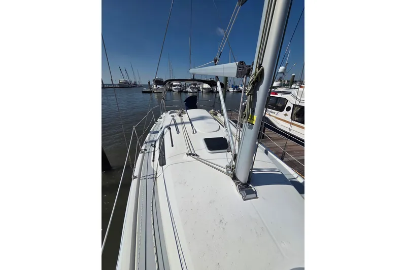 Slide: The Image of 2005 Hunter 31 sailboat docked at marina under clear blue sky. - 22