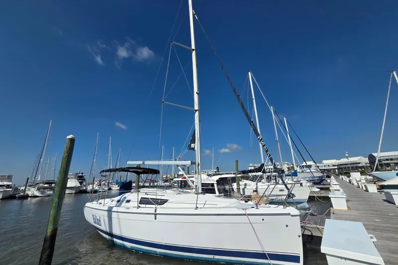 Slide: The Image of 2005 Hunter 31 sailboat docked at marina under clear blue sky. - 25