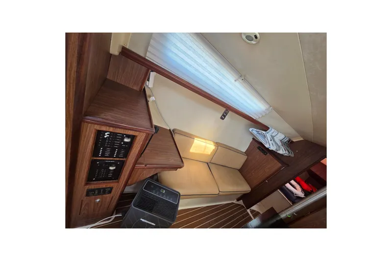 Slide: The Image of Interior of a 2005 Hunter 31 sailboat with beige seating and wooden cabinetry. - 6