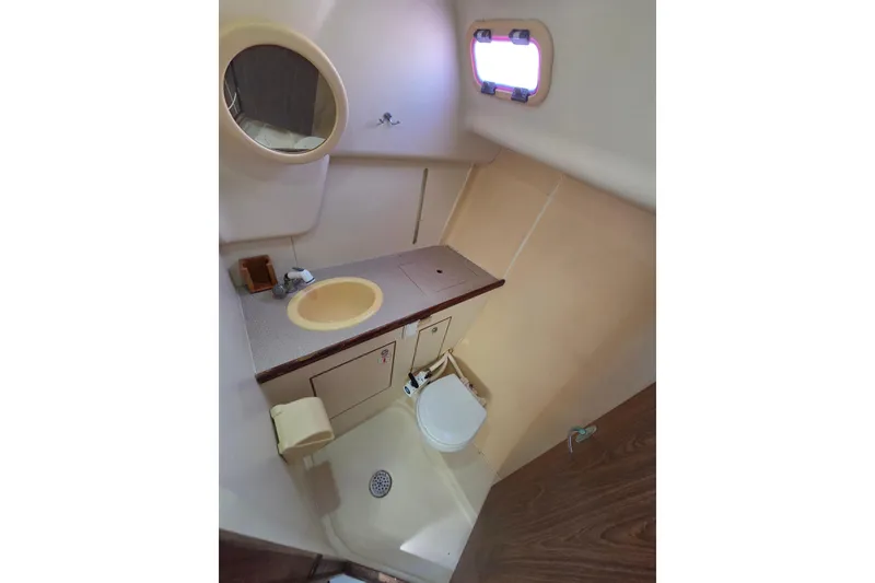 Slide: The Image of Compact bathroom in a 2005 Hunter 31 sailboat with sink, toilet, and mirror. - 9