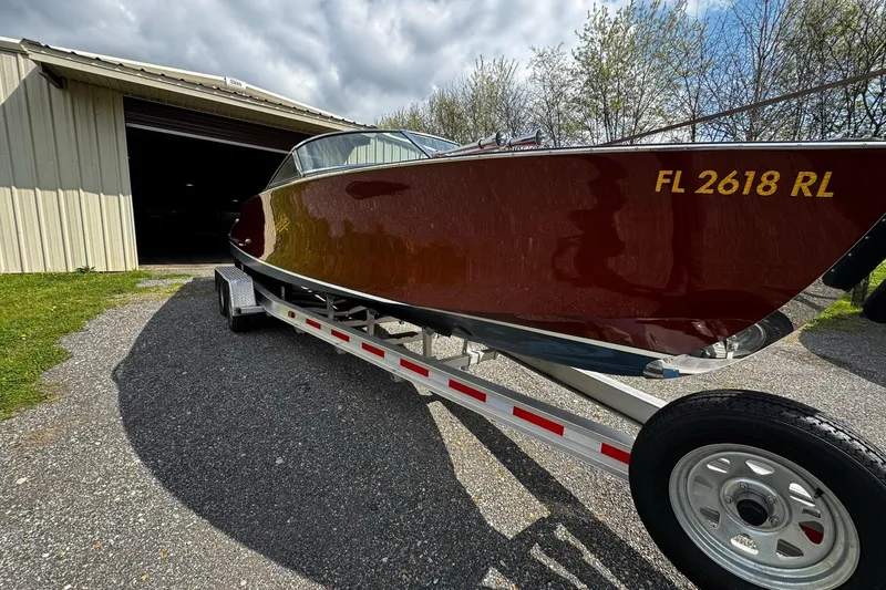 Slide: The Image of 2016 Hacker-Craft 28 Sport boat on trailer near a garage. - 10