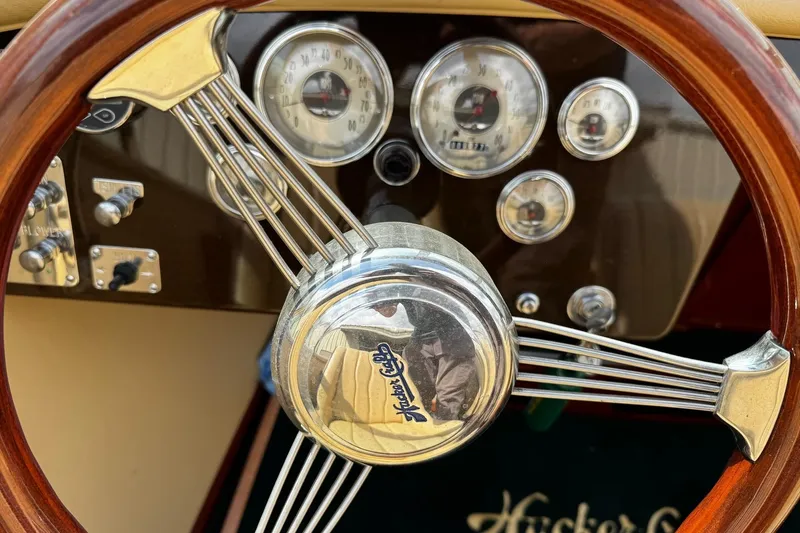 Slide: The Image of Steering wheel and dashboard of 2016 Hacker-Craft 28 Sport boat, featuring classic gauges. - 12