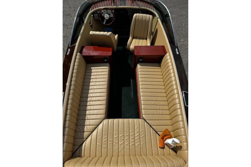 Slide: The Image of 2016 Hacker-Craft 28 Sport boat interior with tan leather seating and wooden accents. - 16