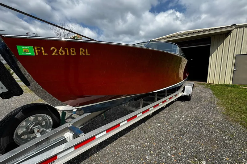 Slide: The Image of 2016 Hacker-Craft 28 Sport boat on trailer, parked outside a metal building. - 2
