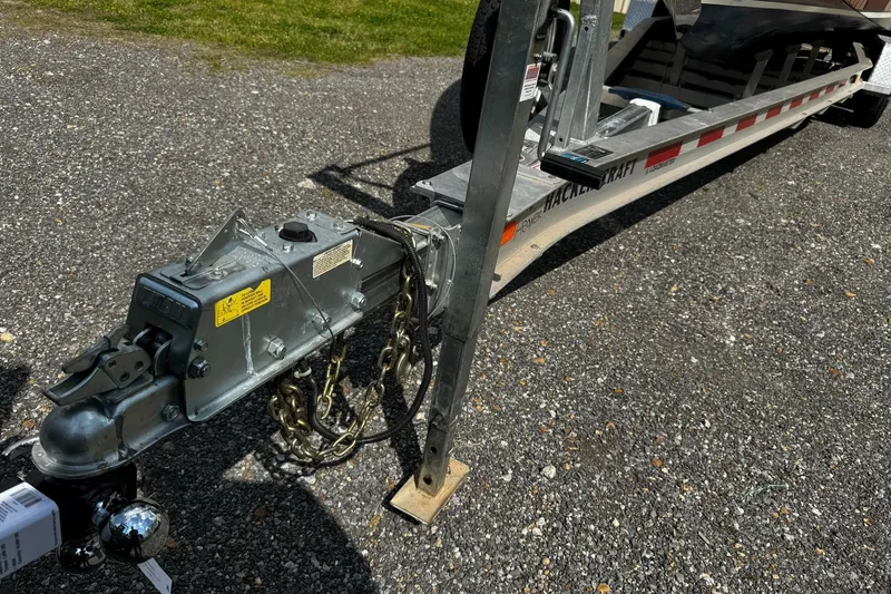 Slide: The Image of Trailer hitch of a 2016 Hacker-Craft 28 Sport boat on gravel surface. - 23