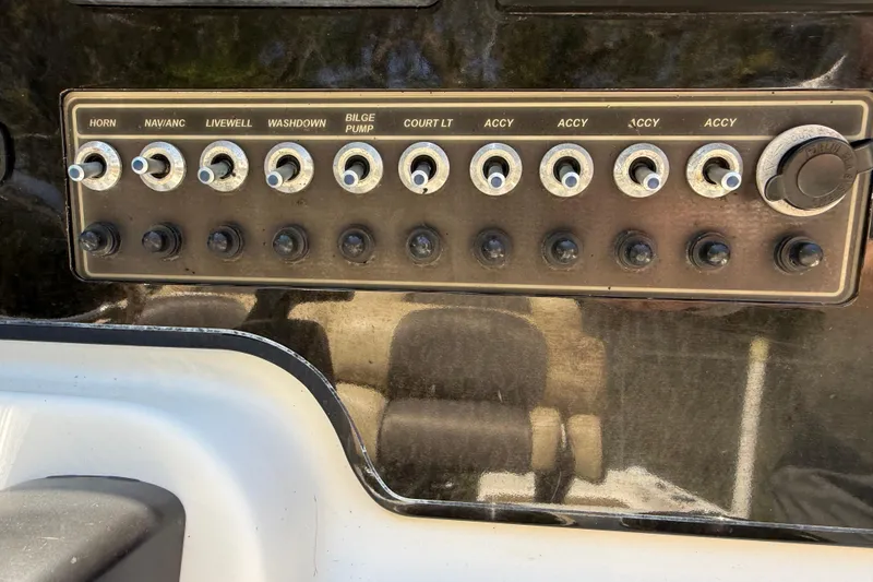 Slide: The Image of Control panel of a 2016 Tidewater 2110 Bay Max boat with labeled switches. - 13