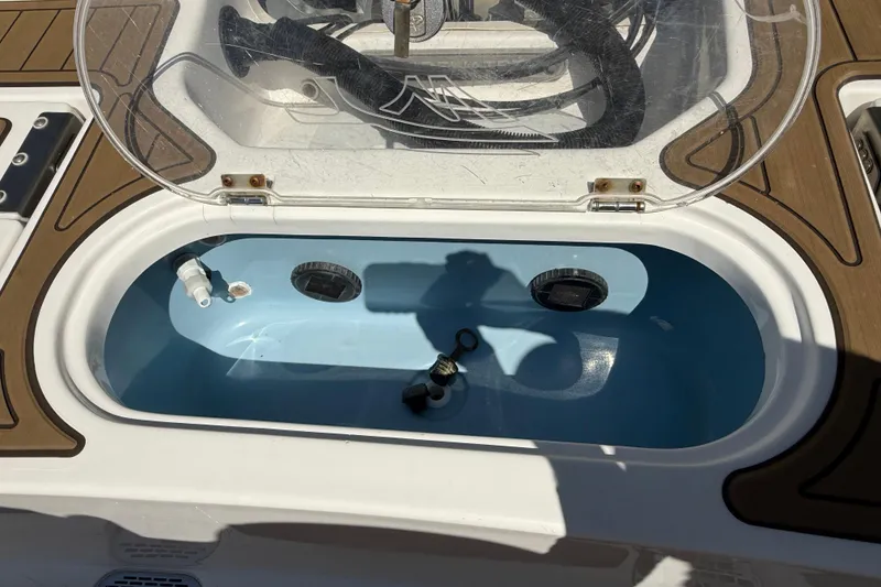 Slide: The Image of Open livewell on 2016 Tidewater 2110 Bay Max boat, featuring a blue interior. - 23