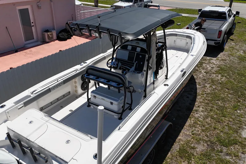 Slide: The Image of 2006 Wellcraft 32 CCF boat with center console, parked on grass near a house and truck. - 11