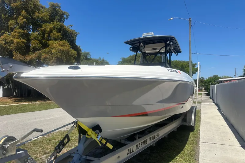 Slide: The Image of 2006 Wellcraft 32 CCF boat on trailer, parked outdoors under clear blue sky. - 2