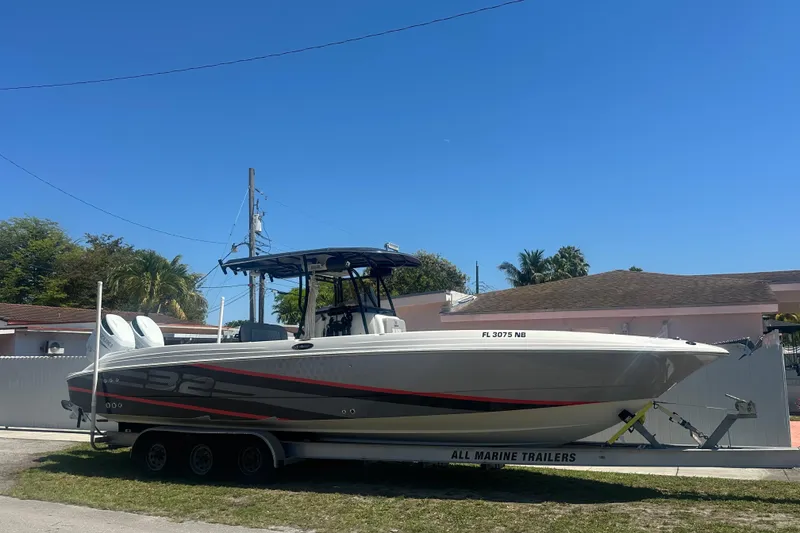 Slide: The Image of 2006 Wellcraft 32 CCF boat on trailer, parked outdoors under clear blue sky. - 6