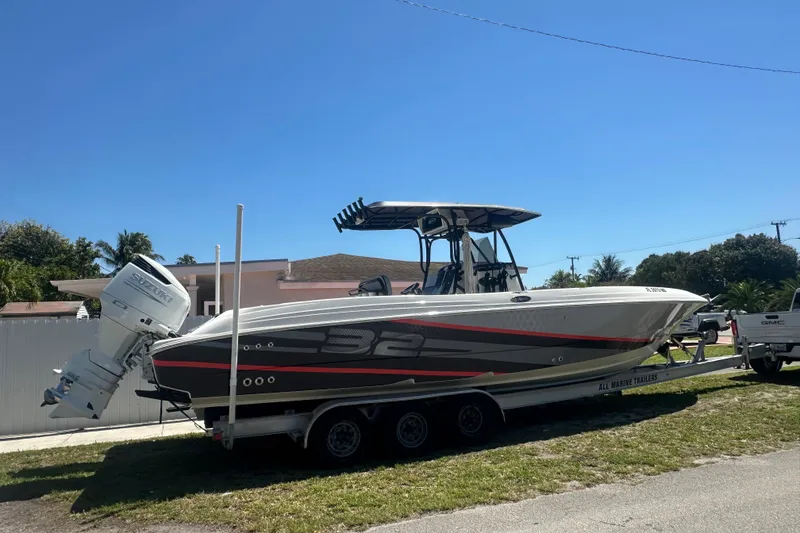 Slide: The Image of 2006 Wellcraft 32 CCF boat on trailer, parked outdoors under clear blue sky. - 7