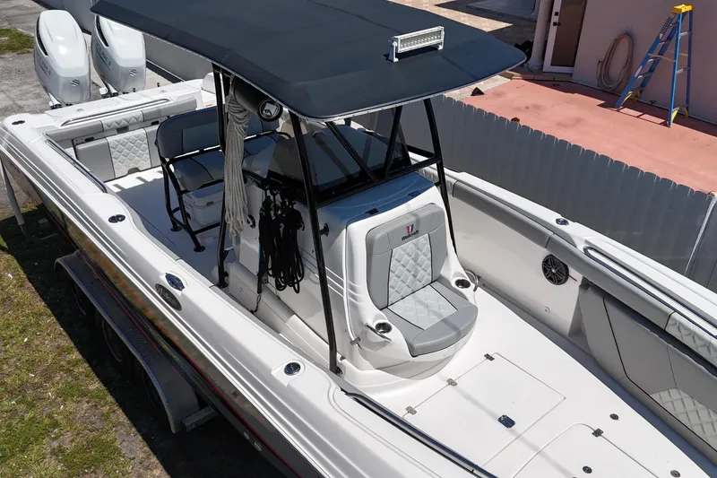 Slide: The Image of 2006 Wellcraft 32 CCF boat with T-top and dual engines, parked on a trailer. - 9