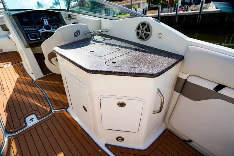 Slide: The Image of 2017 Hurricane SunDeck 2690 OB boat interior with helm and kitchenette area. - 11