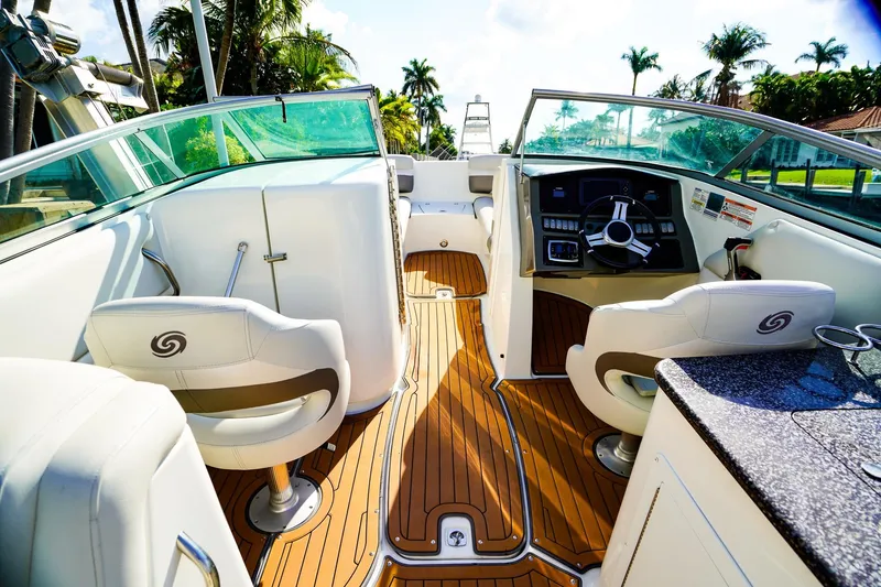 Slide: The Image of 2017 Hurricane SunDeck 2690 OB boat interior with helm, seating, and teak flooring. - 13