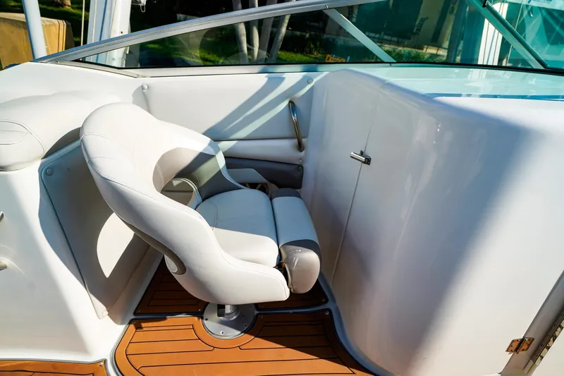 Slide: The Image of 2017 Hurricane SunDeck 2690 OB boat interior with white captain's chair and wooden flooring. - 14