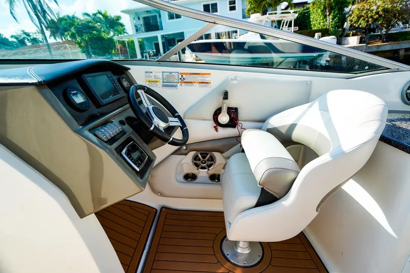 Slide: The Image of 2017 Hurricane SunDeck 2690 OB boat cockpit with steering wheel and captain's chair. - 17