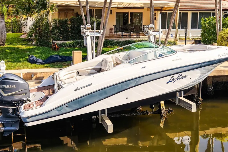 Slide: The Image of 2017 Hurricane SunDeck 2690 OB boat docked with Yamaha engine, near waterfront home. - 2