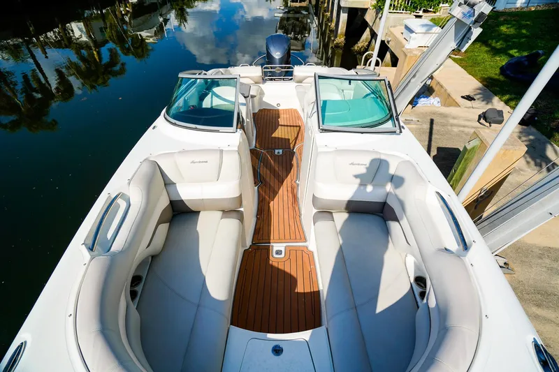 Slide: The Image of 2017 Hurricane SunDeck 2690 OB boat with spacious seating and sleek design on calm water. - 21