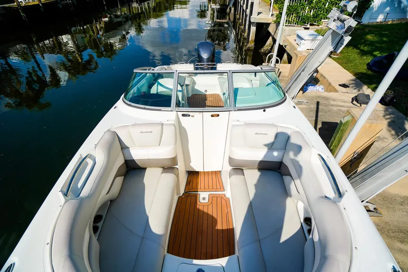 Slide: The Image of 2017 Hurricane SunDeck 2690 OB boat with spacious seating and sleek design docked by the water. - 22