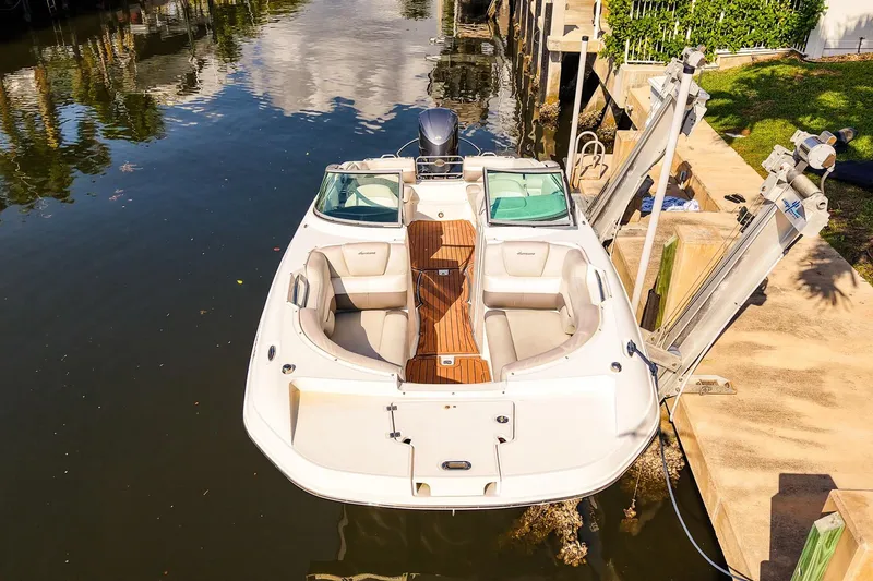 Slide: The Image of 2017 Hurricane SunDeck 2690 OB boat docked by a canal, featuring spacious seating. - 23