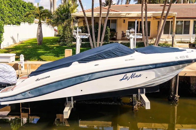 Slide: The Image of 2017 Hurricane SunDeck 2690 OB boat docked near a waterfront home. - 25