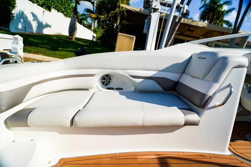 Slide: The Image of 2017 Hurricane SunDeck 2690 OB boat interior with white seating and speaker. - 9