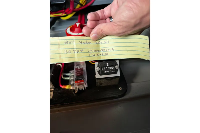 Slide: The Image of Hand holding note with 2019 Hacker-Craft 23 RUNABOUT details, showing boat's hull ID and hour meter. - 11