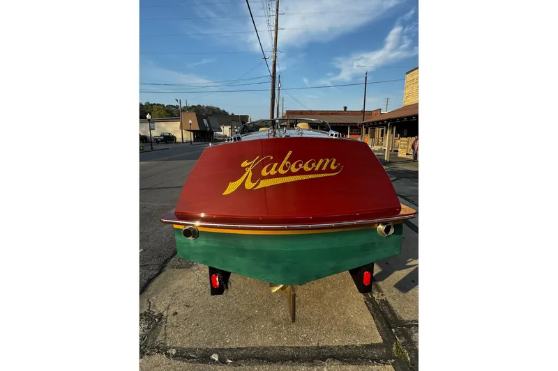 Slide: The Image of 2019 Hacker-Craft 23 Runabout boat with "Kaboom" on the stern, parked on a street. - 25