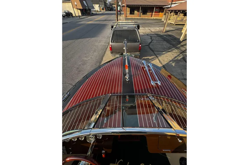 Slide: The Image of 2019 Hacker-Craft 23 Runabout with polished wood finish, parked on a street. - 7