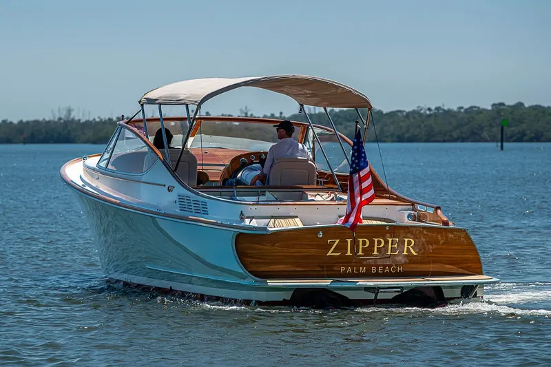 The Image of 2017 Hinckley Talaria 34R boat cruising on calm waters, featuring elegant design and American flag. - 0