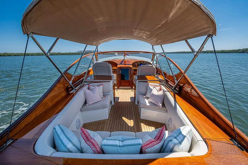 Slide: The Image of Hinckley Talaria 34R 2017 yacht interior with plush seating and American flag on calm waters. - 11