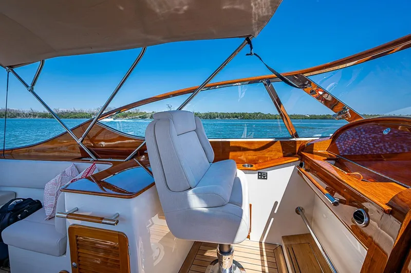 Slide: The Image of Luxurious 2017 Hinckley Talaria 34R yacht interior with wooden dashboard and scenic water view. - 18