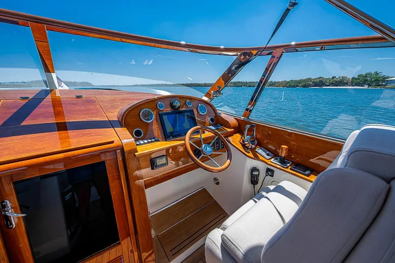 Slide: The Image of 2017 Hinckley Talaria 34R helm with wooden dashboard, steering wheel, and navigation equipment. - 19
