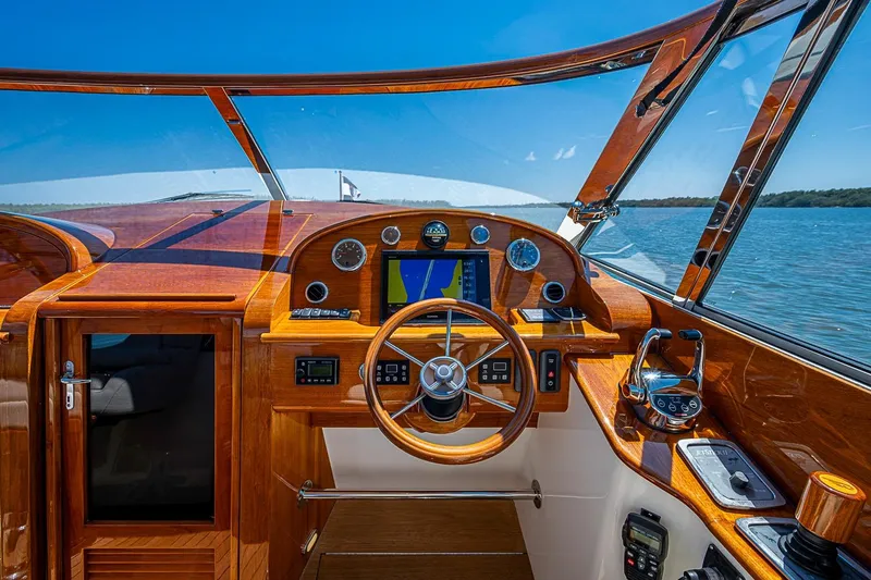 Slide: The Image of Cockpit view of 2017 Hinckley Talaria 34R yacht with elegant wood finish and scenic water backdrop. - 20