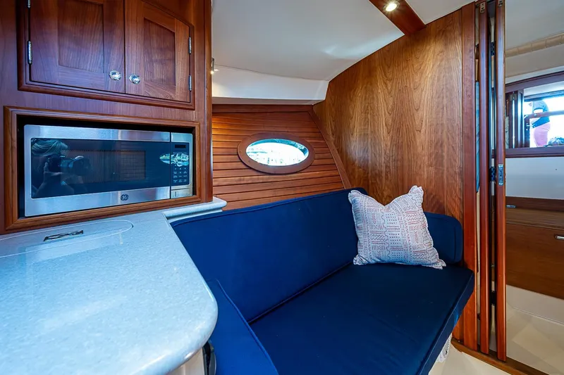 Slide: The Image of Interior of 2017 Hinckley Talaria 34R yacht with blue sofa and wooden paneling. - 23
