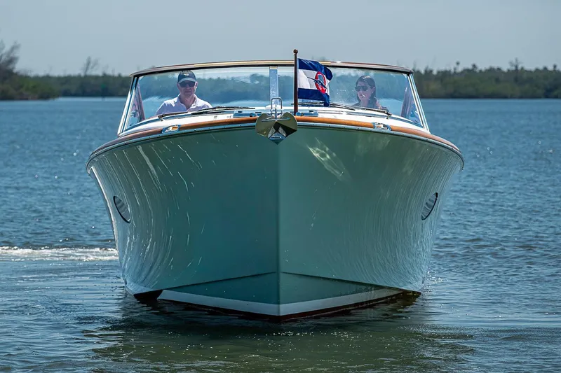 Slide: The Image of 2017 Hinckley Talaria 34R boat cruising on calm water with canopy and flags. - 3