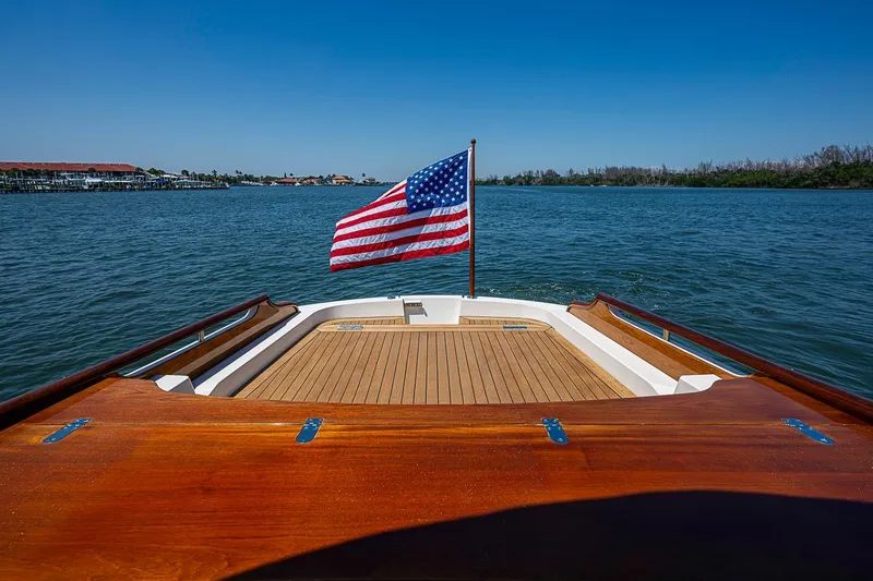 Slide: The Image of Luxurious 2017 Hinckley Talaria 34R yacht with elegant seating and American flag on calm waters. - 7
