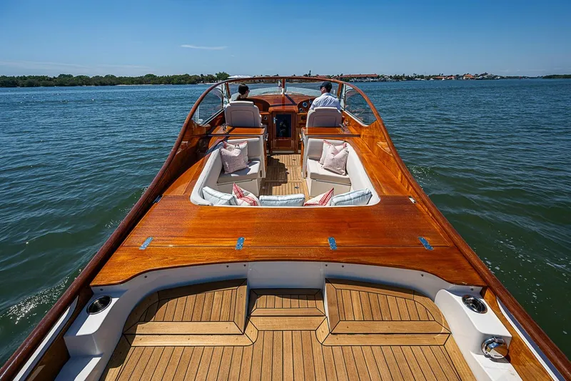 Slide: The Image of 2017 Hinckley Talaria 34R cruising on calm waters, featuring elegant wooden deck and seating. - 9