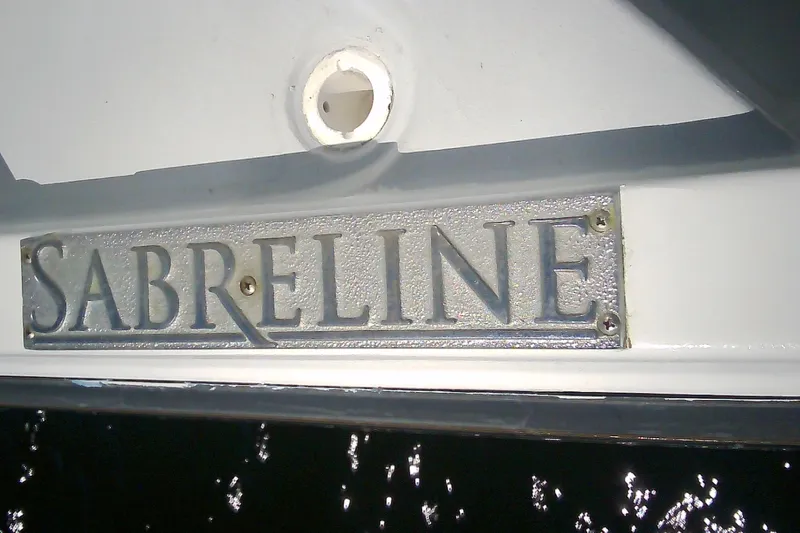 Slide: The Image of 1999 Sabre 34 boat with "Sabreline" nameplate, reflecting sunlight on water. - 10