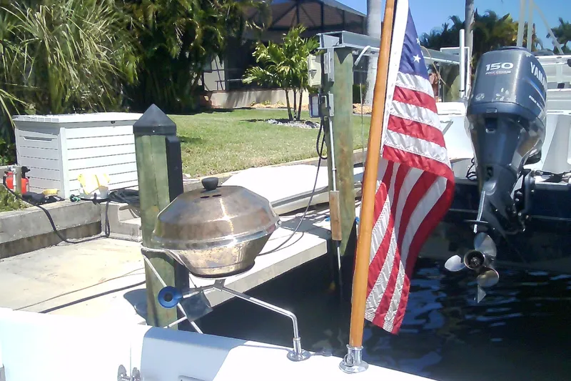 Slide: The Image of Boat docked with American flag and grill, featuring a Yamaha outboard motor. Sabre 34, 1999 model. - 17
