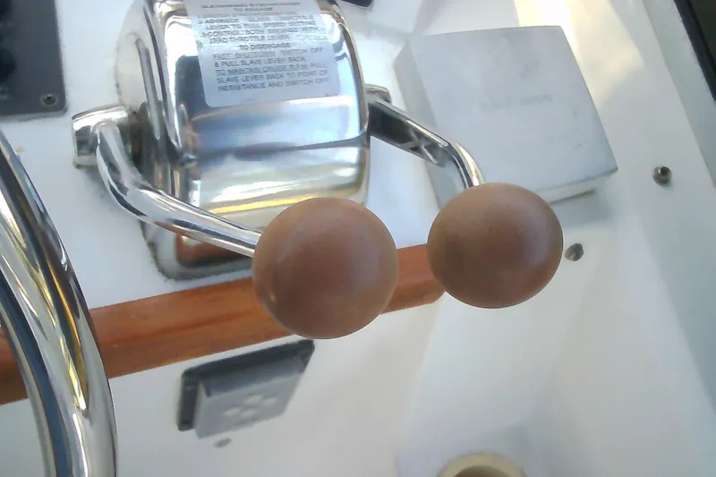 Slide: The Image of Throttle controls on a 1999 Sabre 34 boat, featuring wooden handles and chrome finish. - 19