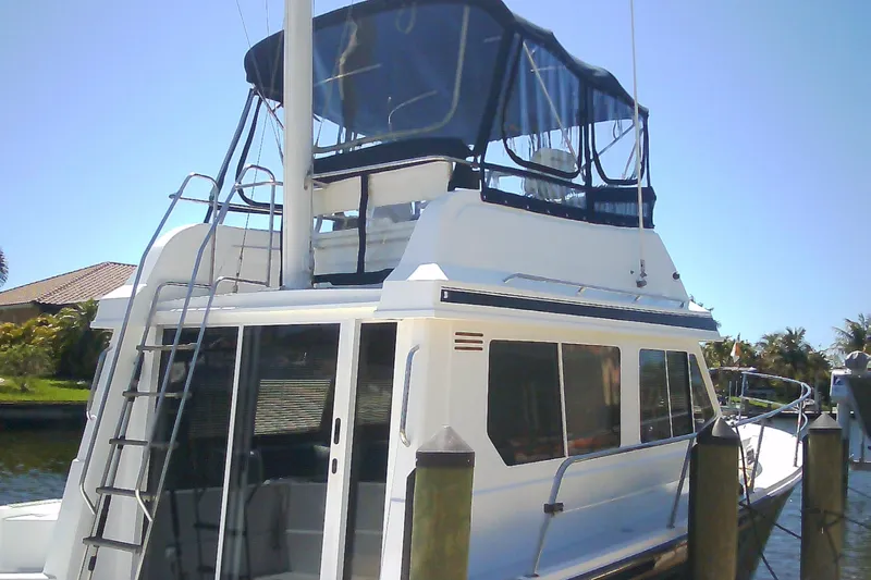 Slide: The Image of 1999 Sabre 34 yacht docked, featuring a flybridge and sleek design. - 2