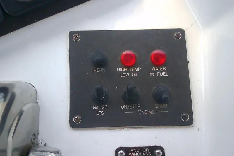 Slide: The Image of Control panel of a 1999 Sabre 34 boat with indicator lights and switches. - 23